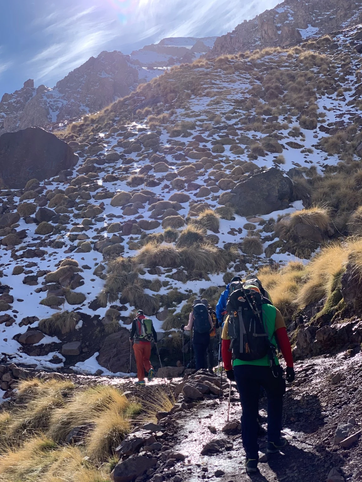 Snowy High Atlas ridge with trekkers near Mount Toubkal, Morocco